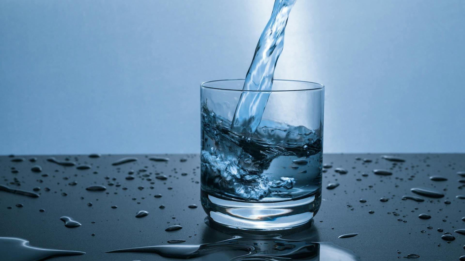 Clear blue water being poured into a glass